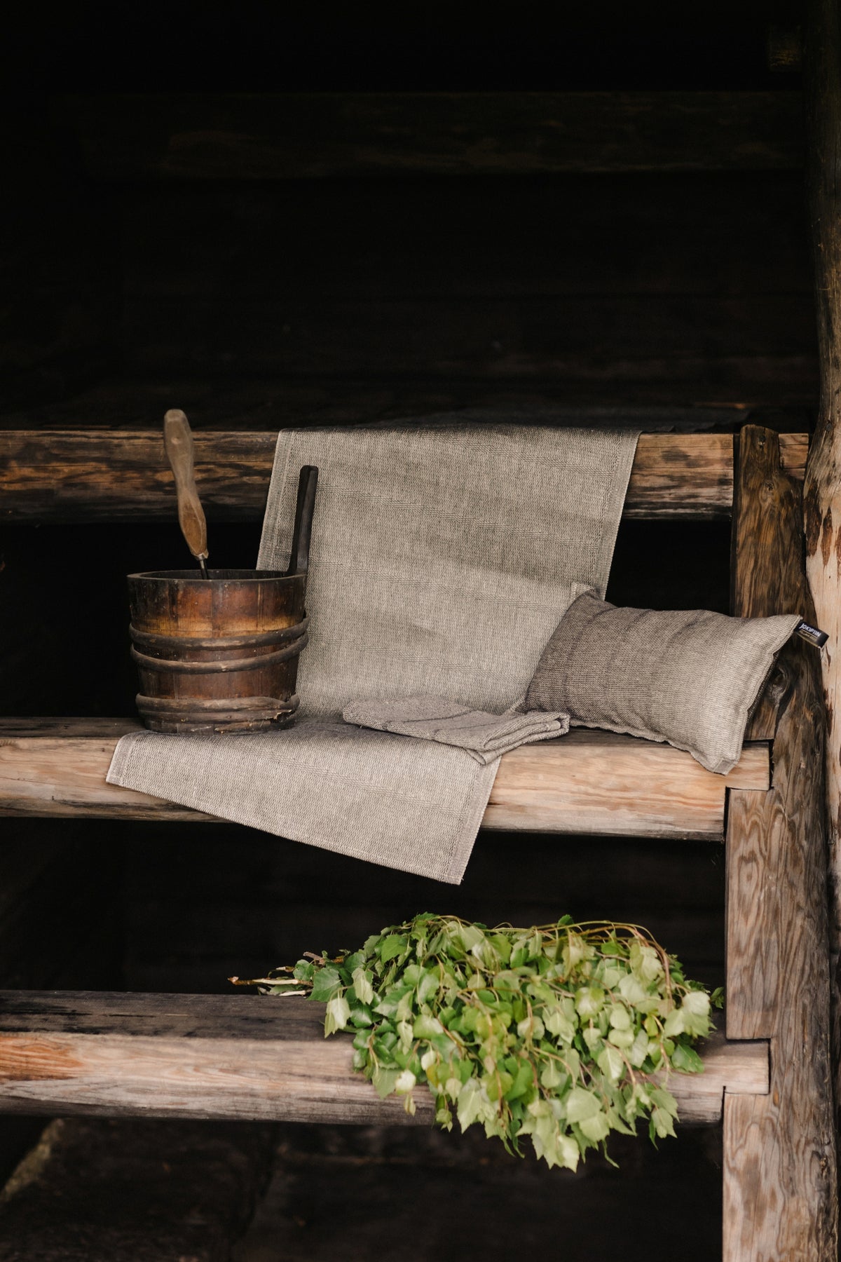 Laituri natural/black seat cover styled on a bench in a traditional Finnish sauna